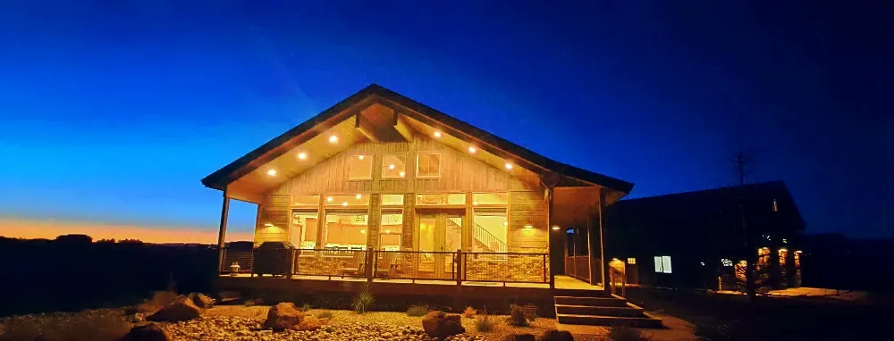 Great-room windows glowing at night